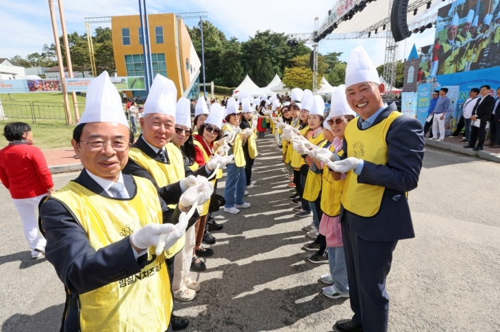 심민(왼쪽) 임실군수가 5일 임실N치즈축제에 참가한 관광객들과 함께 치즈 늘리기 체험을 선보이고 있다. 임실군 제공