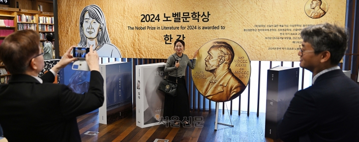 14일 서울 종로구 교보문고 광화문점에 마련된 2024 노벨문학상 수상자 한강 작가의 책 판매 부스에서 시민들이 기념 촬영을 하고 있다. 2024.10.14 오장환 기자