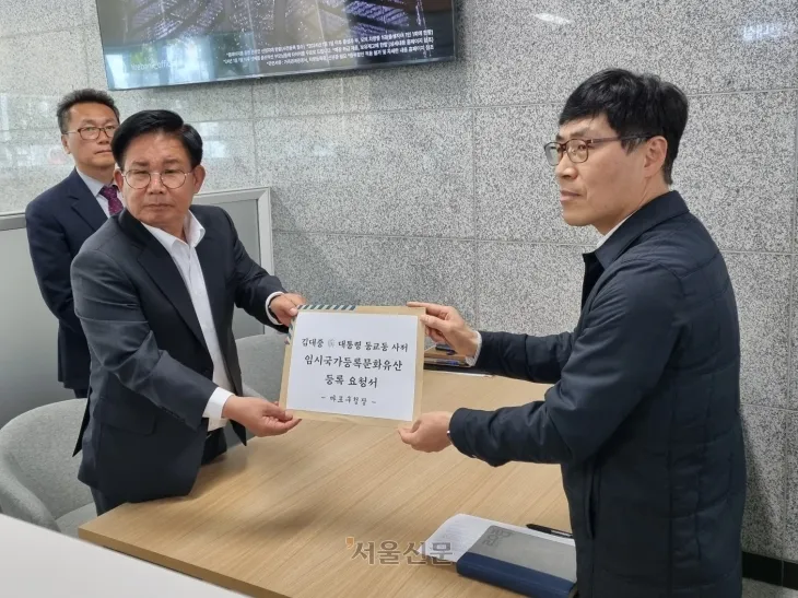 박강수(왼쪽) 서울 마포구청장이 21일 정부 대전청사에서 고 김대중 전 대통령 사저 임시국가등록문화유산 지정을 촉구하는 공문을 국가유산청 관계자에게 전달하고 있다.