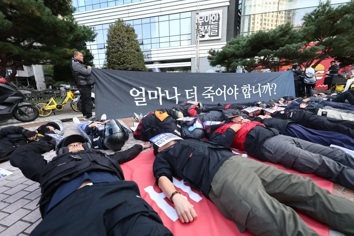 30일 오후 서울 송파구 우아한형제들 본사 앞에서 공공운수노조 라이더유니온 조합원들이 기본 배달운임 인상과 배달 기사의 요구가 반영된 배달앱 상생협의체 상생안을 촉구하며 ‘다잉 퍼포먼스’를 하고 있다. 2024.10.30. 연합뉴스