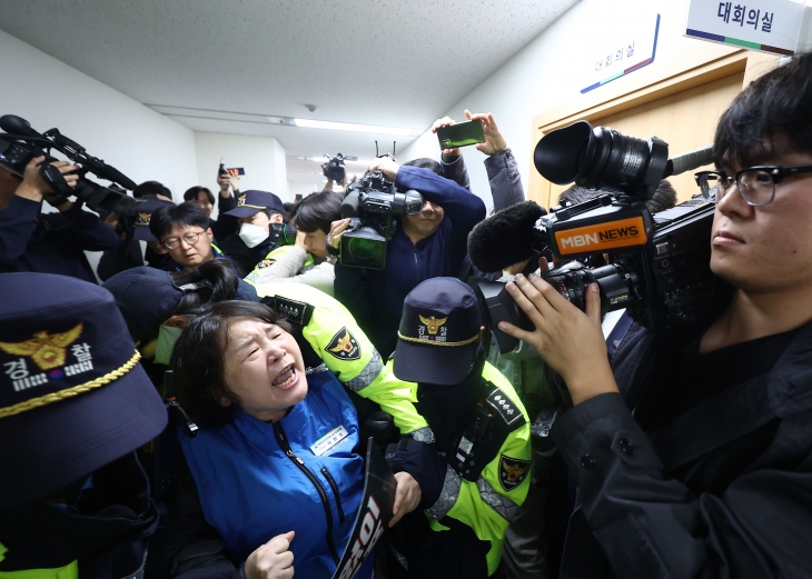 지난달 22일 공무원 근무시간면제 심의위원회 11차 전원회의가 열리는 서울 종로구 경제사회노동위원회 회의실 앞에서 대한민국공무원노동조합총연맹 관계자가 근무시간 면제(타임오프) 한도 의결 과정에 대한 규탄 발언을 하던 중 경찰과 실랑이를 벌이고 있다. 연합뉴스