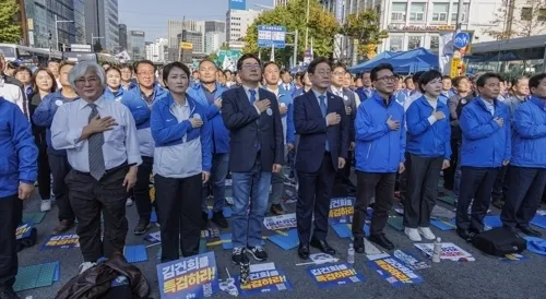 더불어민주당 이재명(앞줄 왼쪽 네 번째) 대표와 박찬대(앞줄 왼쪽 세 번째) 원내대표를 비롯한 민주당 지도부와 의원들이 2일 서울 중구 서울역 일대에서 더불어민주당 주최로 열린 김건희 윤석열 국정농단 규탄·특검 촉구 국민행동의 날에 참가해 국기에 경례하고 있다.  연합뉴스