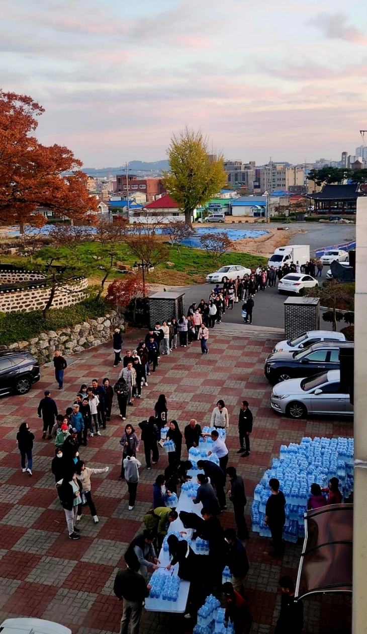 단수로 물 공급이 끊긴 가운데 태안군 주민들이 태안읍사무소에서 나눠주는 물을 받으려고 줄 서 있다.