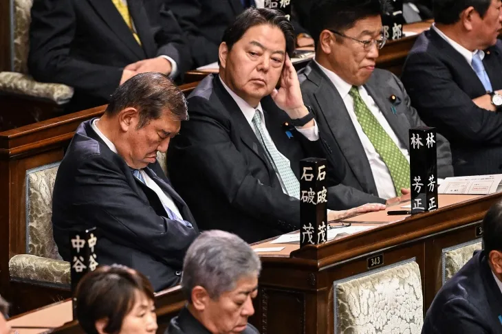 이시바 시게루 일본 총리가 11일 중의원(하원) 본회의 총리지명 선거 도중 눈을 감은 채 고개를 숙이고 있다. 옆에 앉은 하야시 요시마사 관방장관이 그 모습을 지켜보고 있다. AFP 연합뉴스