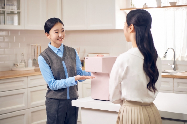 코웨이 방문점검판매원 ‘코디’(왼쪽)가 제품을 설명하고 있다. 코웨이 제공