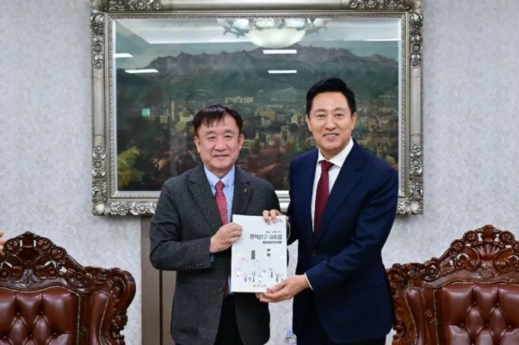 위원장단-서울시장 소통간담회에서 오세훈 서울시장에게 연구자료집을 전달하는 경기문 정책위원장