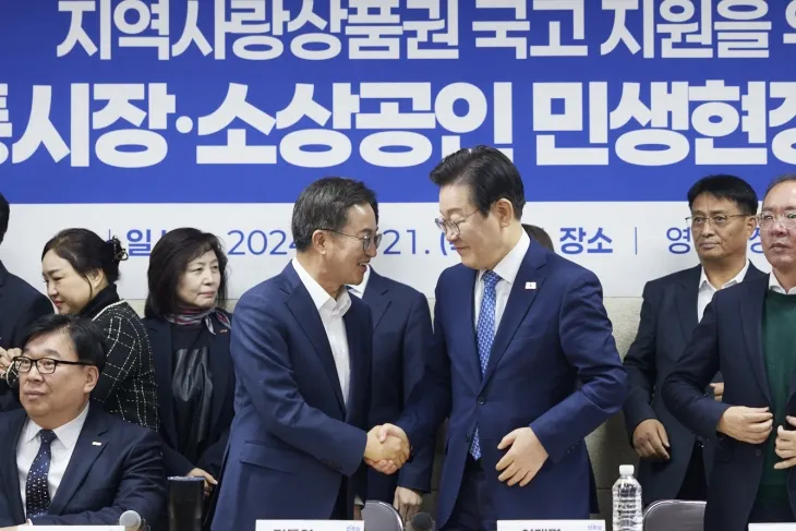 21일 수원 영동시장에서 열린 지역사랑상품권 국고 지원을 위한 전통시장·소상공인 간담회에 앞서 김동연 경기도지사와 이재명 더불어민주당 대표가 악수를 하고 있다. (경기도 제공)