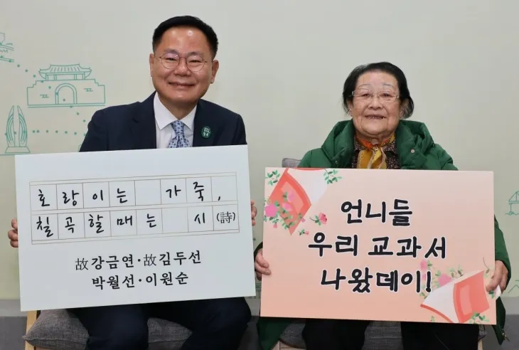 김재욱(왼쪽) 경북 칠곡군수와 천재교과서에 자신의 시가 실린 이원순 할머니가 교과서 수록을 기념하는 팻말을 들고 기뻐하고 있다. 칠곡군청 제공