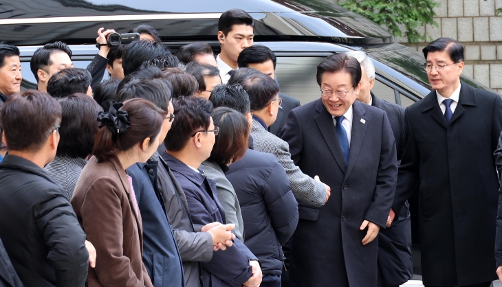 이재명 더불어민주당 대표가 25일 서울 서초구 서울중앙지법에서 열린 위증교사 사건 1심 선고 공판에 출석하며 민주당 의원들과 인사하고 있다. 2024.11.25 뉴시스