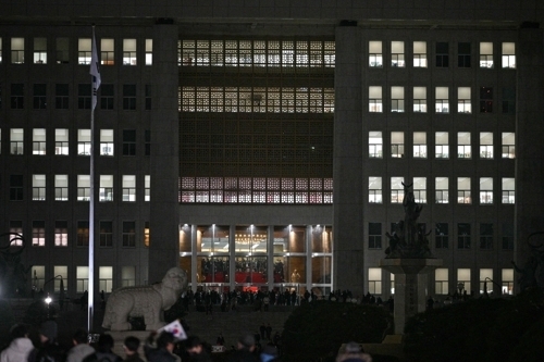 윤석열 대통령의 계엄령 선포 직후 3일 밤 국회의사당 본관 앞에서 무장계엄군과 진입을 막는 인파들이 대치하고 있다. AFP 연합뉴스