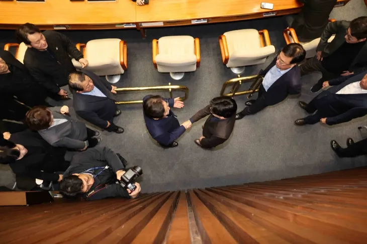 윤석열 대통령이 긴급 대국민 담화를 통해 비상계엄령을 발표한 가운데 4일 서울 여의도 국회 본회의장에 한동훈 국민의힘 대표와 이재명 민주당 대표가 만나 악수하고 있다. 2024.12.4 뉴시스