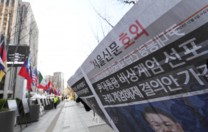 윤석열 대통령이 비상계엄을 선포한 지 6시간여만에 국무회의에서 계엄 해제안이 의결된 가운데 4일 오전 서울 중구 인근에서 시민들이 호외를 읽고 있다. 2024.12.4 홍윤기 기자