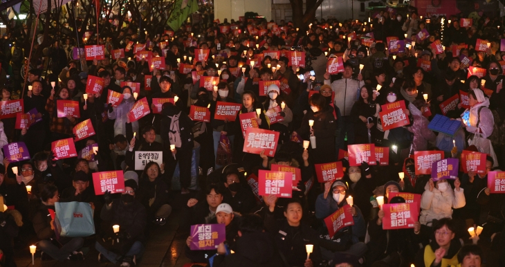 5일 오후 서울 종로구 동화면세점 앞에서 열린 윤석열 대통령 퇴진 촉구 집회에 참여한 시민들이 촛불을 들고 정권 퇴진을 촉구하고 있다. 2024.12.5 뉴스1