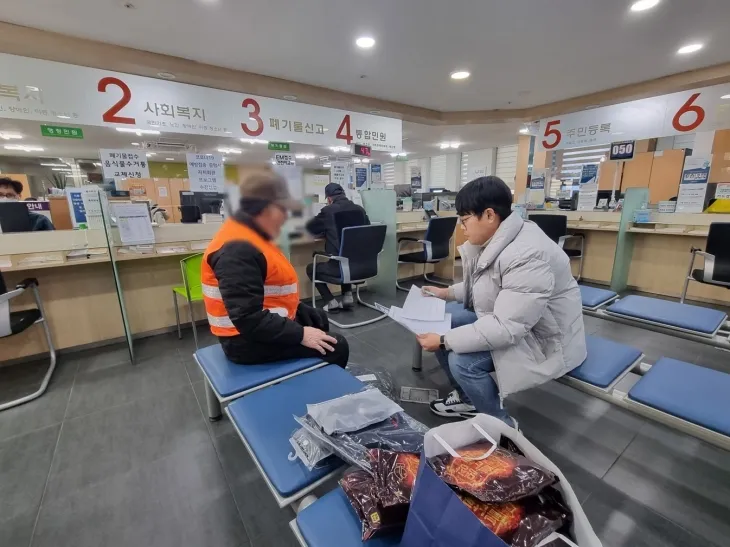 서울 광진구 관계자가 폐지수집 어르신에게 방한용품을 전달하고 있다. 광진구 제공