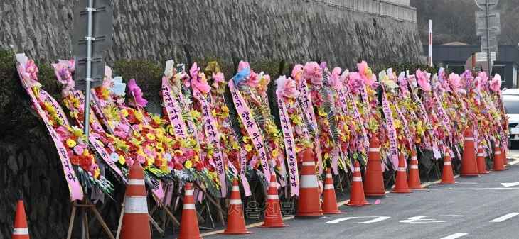 윤석열 대통령의 지지자들이 탄핵에 반대하는 뜻을 밝히고 윤 대통령을 응원하기 위해 보낸 화환이 11일 서울 용산 대통령실 청사 입구 부근에 줄지어 놓여 있다. 화환에는 “윤석열을 지키자”, “윤 대통령을 지키는 게 나라를 지키는 것이다!”라는 등의 문구가 적혀 있다. 도준석 전문기자