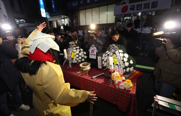 11일 오후 대구 수성구 국민의힘 대구시당 앞에서 열린 대구촛불행동 주최 ‘국짐당 국민 장례식’에 설치된 빈소에서 상복차림을 한 참석자가 춤을 추고 있다. 2024.12.11. 연합뉴스