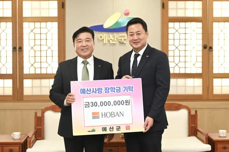 호반장학재단 송진오(오른쪽) 사무국장이 12일 예산군청에서 최재구 군수에게 장학금 3000만원을 기탁하고 있다.