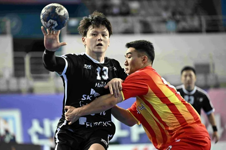 SK 호크스의 이현식(왼쪽)이 핸드볼 H리그 상무 피닉스와의 경기에서 상대 수비를 피해 패스하고 있다.  한국핸드볼 연맹 제공