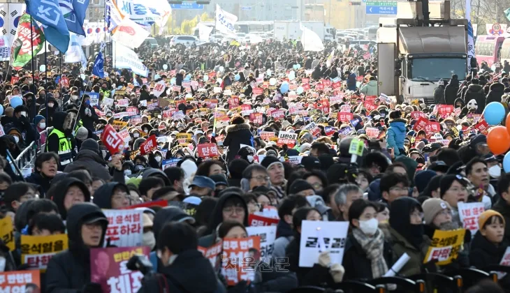 윤석열 대통령 탄핵소추안이 가결된 14일 오후 서울 여의도 국회의사당 앞에 모인 시민들이 ‘윤석열 퇴진’ 등의 피켓을 들고 구호를 외치고 있다. 홍윤기 기자