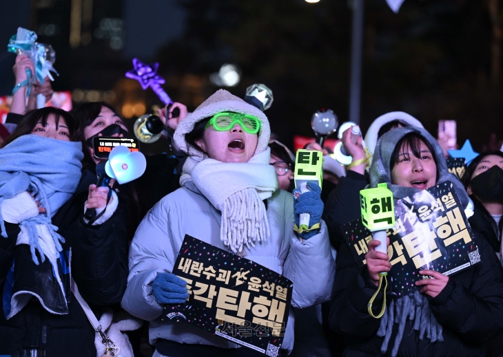 지난 14일 윤석열 대통령 탄핵소추안이 가결되자 서울 여의도 국회 앞에 모인 시민들이 K팝 콘서트장에서 사용되는 응원봉 등을 흔들며 환호하고 있다. 홍윤기 기자