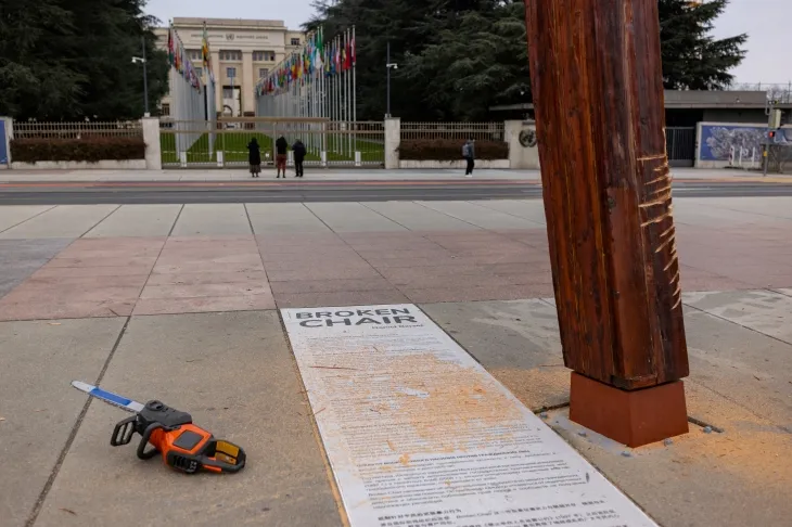 13일(현지시간) 페미니스트 단체 페멘(Femen) 활동가들이 스위스 제네바 유엔유럽본부 앞 광장의 ‘부서진 의자’ 기념비 아래에서 러시아의 유엔 추방을 요구하는 시위를 벌였다. 상처가 남은 작품. 로이터 연합뉴스