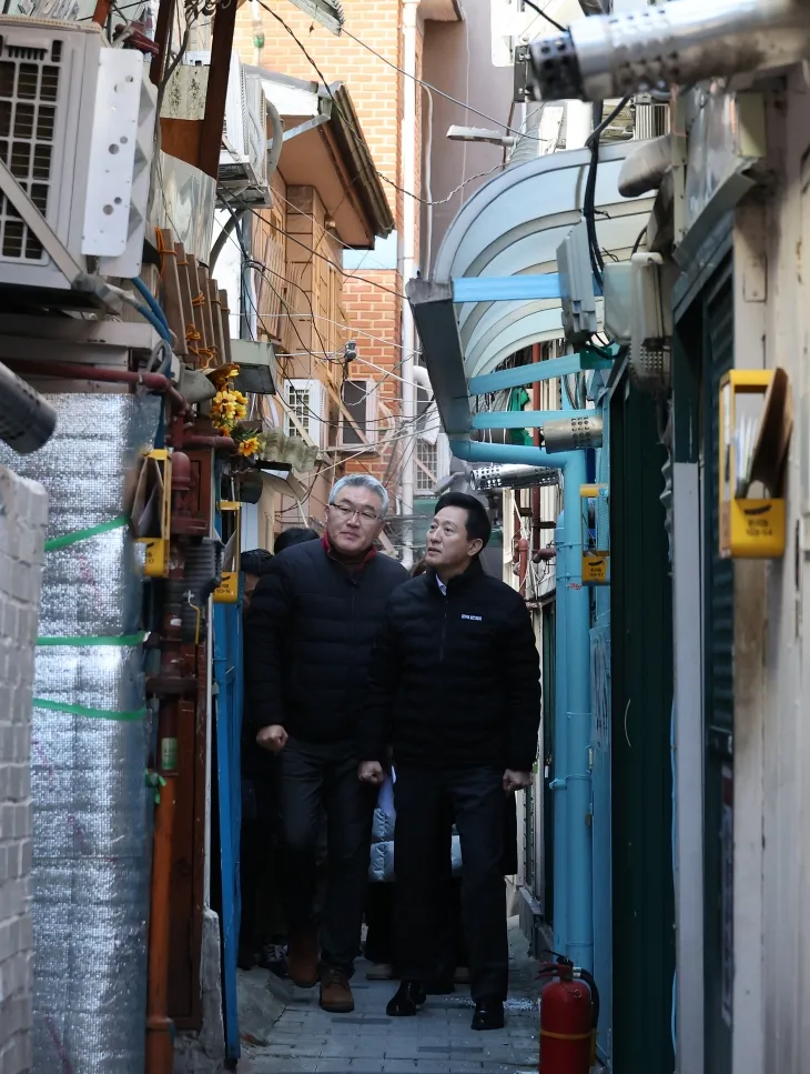 한파 대비 쪽방촌 현장 점검에 나선 오세훈 서울시장이 18일 오전 서울 종로구 돈의동 쪽방촌 골목을 최영민 서울시립 돈의동쪽방상담소 최영민 소장과 함께 살펴보고 있다.   연합뉴스