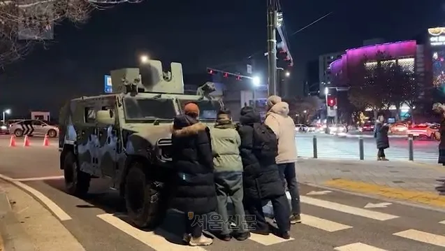 지난 3일 비상계엄 사태 당시 한 시민들이 장갑차를 막아서고 있다. 워싱턴포스트 웹사이트 캡처