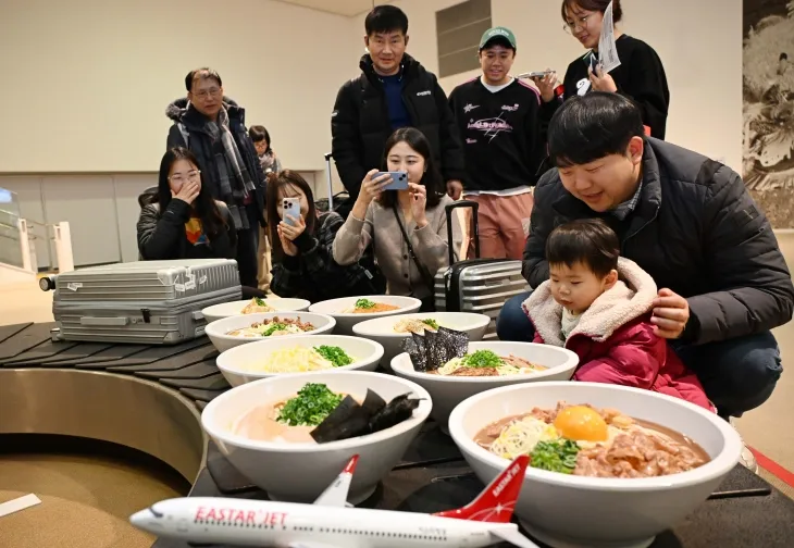 26일 오후 일본 도쿠시마공항에서 열린 ‘이스타항공 도쿠시마 첫 취항 기념 행사’에서 탑승객들이 공항 수하물 컨베이어 벨트에 전시된 ‘도쿠시마 라멘 모형’을 관람하고 있다. 이스타항공이 국내 최초로 단독 취항하는 인천-도쿠시마 노선은 주 3회(화, 목, 토) 운항한다. 2024.12.26 도쿠시마 도준석 전문기자