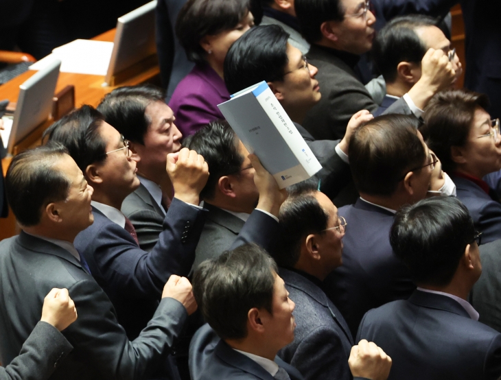 국민의힘 의원들이 27일 오후 국회 본회의에서 한덕수 국무총리 탄핵소추안 투표가 진행되는 동안 ‘헌법재판소법’을 들고 우원식 의장에게 항의하고 있다.  2024.12.27 연합뉴스