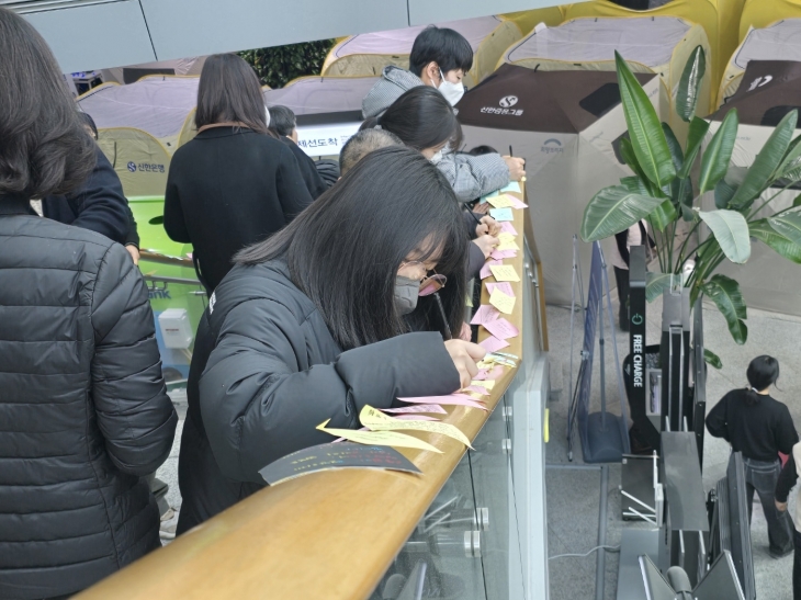 무안국제공항을 찾은 참배객들이 계단 손잡이에 ‘추모의 글’을 써 붙이고 있다. 무안 홍행기 기자