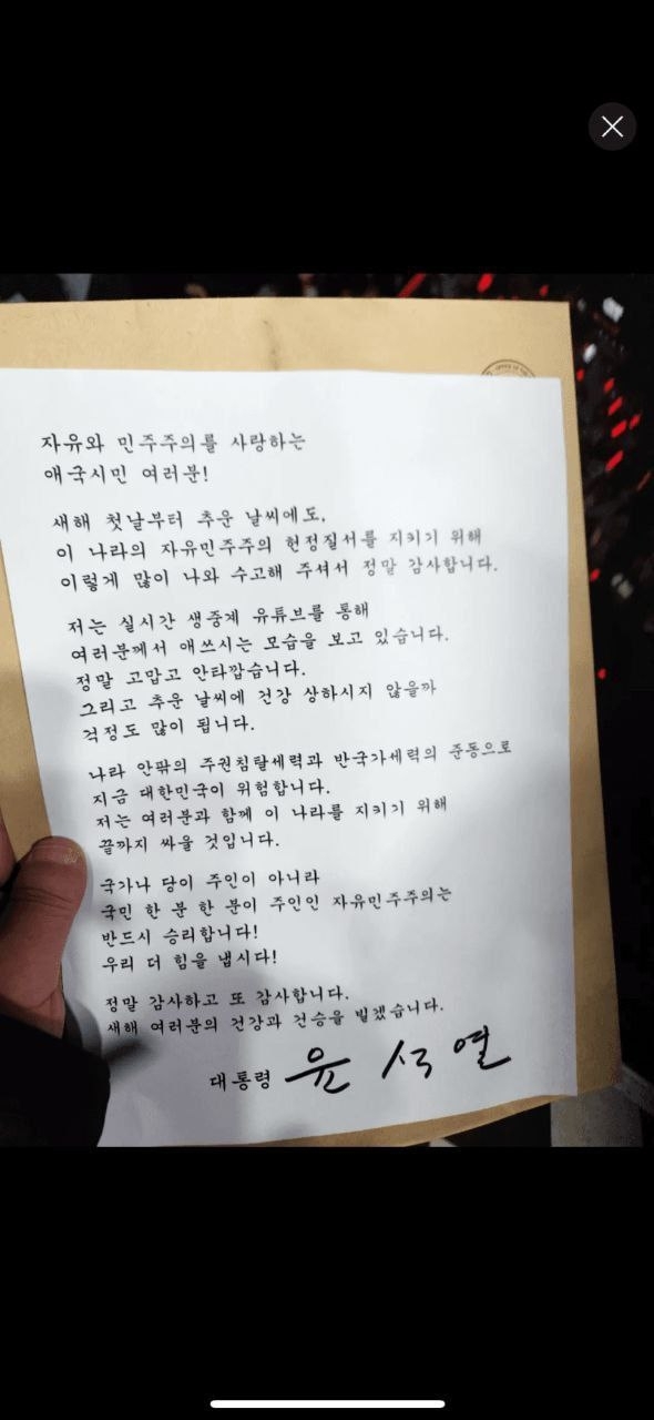 윤석열 대통령이 1일 한남동 관저 앞에서 집회 중인 지지자들에게 “끝까지 싸울 것”이라고 밝혔다. 사진은 윤 대통령의 편지가 담긴 유인물. 연합뉴스