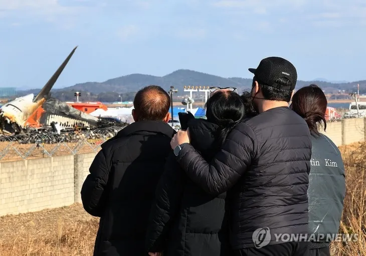 무안국제공항 제주항공 여객기 참사 현장에서 유가족들이 여객기 잔해를 바라보고 있다. 연합뉴스.