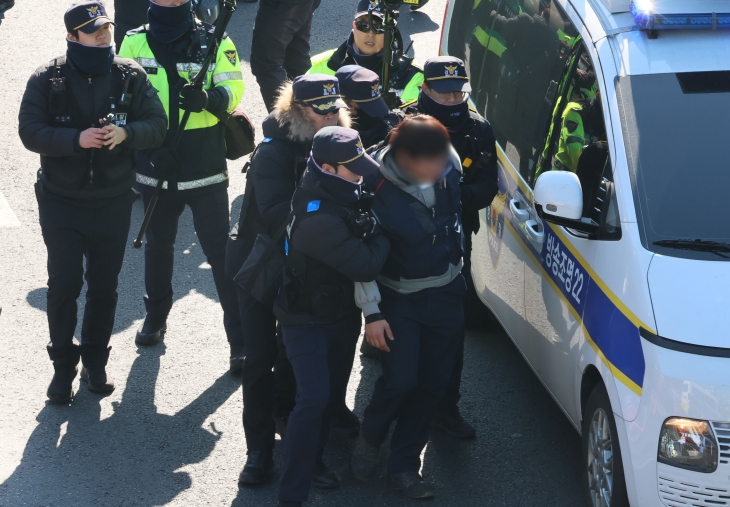 4일 서울 용산구 한남동 대통령 관저 인근에서 집회신고 구간 행진을 시도하다 가로막히자 경찰과 몸싸움을 벌인 민주노총 한 조합원이 연행되고 있다. 2025.1.4. 연합뉴스