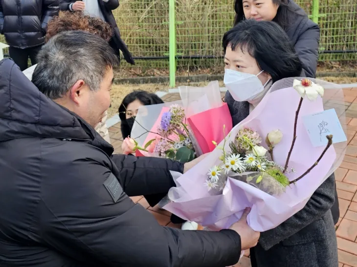 아버지를 살해한 혐의로 무기징역을 확정받은 김신혜 씨(47·여)가 6일 열린 재심을 통해 24년 만에 무죄를 선고 받고 전남 장흥교도소에서 출소하면서 윤성여씨로부터 꽃다발을 건네받고 있다. 2024.1.6/뉴스1