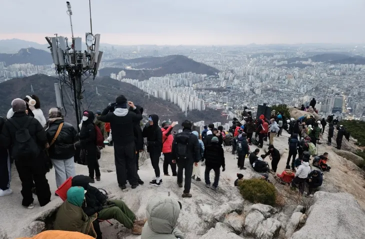 지난 1일 서울 은평구 북한산국립공원 족두리봉에서 해맞이객들이 2025년 첫 일출을 기다리고 있다. 연합뉴스