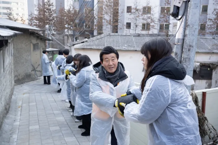 국제라이온스협회 354-D지구 지훈 총재(오른쪽 2번재)와 집행부 관계자, 그리고 숭실대와 국민대클럽캠퍼스 소속 대학생들이 11일 오전  동작구 사당동 정금마을 주민들에게 연탄을 배달하고 있다. [국제라이온스354-D지구 제공]