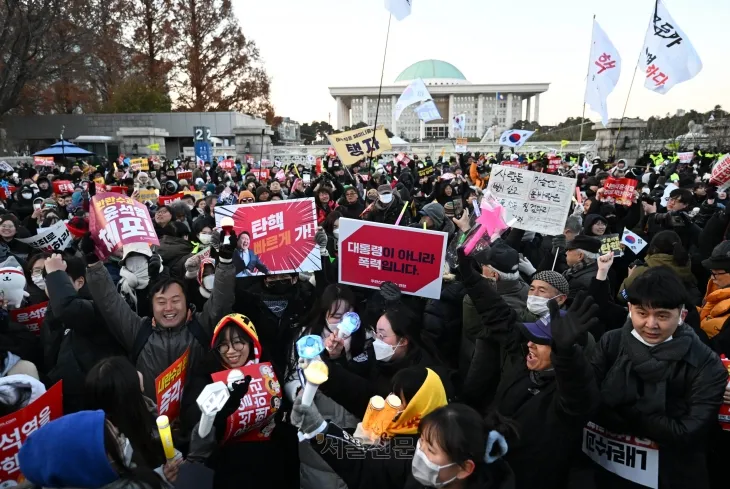 12월 14일 국회 앞에서 열린 윤 대통령 탄핵 촉구 집회에서 참가자들이 탄핵소추안 가결 소식을 듣고 기뻐하는 모습.  홍윤기 기자