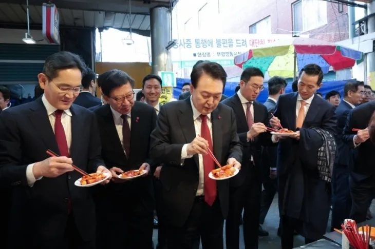 윤석열 대통령이 6일 부산 중구 깡통시장을 방문해 박형준 부산시장, 기업인들과 떡볶이를 시식하고 있다. 왼쪽부터 이재용 삼성전자 회장, 박 시장, 윤 대통령. 2023.12.06 뉴시스