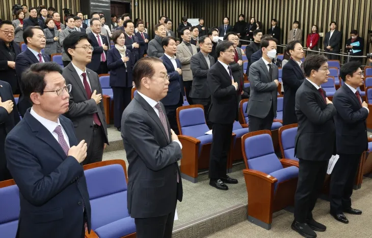 국민의힘 권영세 비상대책위원장(앞줄 왼쪽 두번째)과 권성동 원내대표 등 의원들이 16일 국회에서 열린 비상의원총회에서 국기에 경례하고 있다. 2025.1.16 연합뉴스