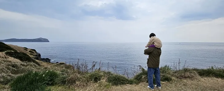 아빠 목마 타고 있는 아이가 성산포바다를 바라보고 있다. 제주 강동삼 기자