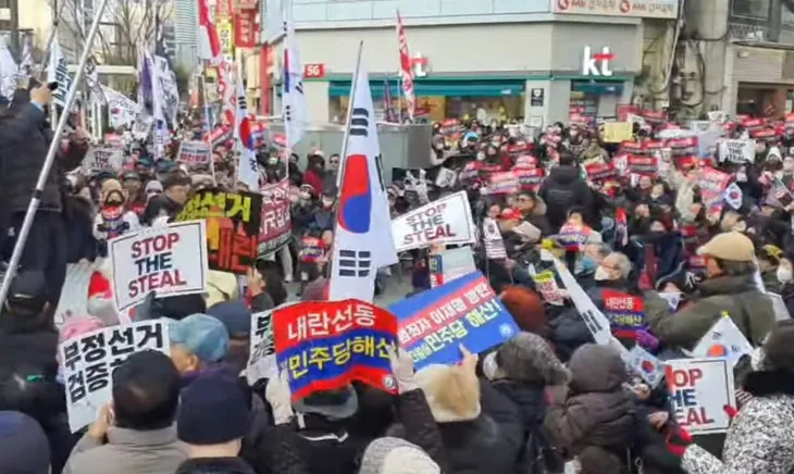 18일 오후 대구 중구 반월당네거리에서 열린 ‘자유대한민국 수호 윤석열 복귀 탄핵 반대 부정선거 척결 집회’에 참석해 태극기와 손팻말을 들고 구호를 외치고 있다. 유튜브 캡쳐