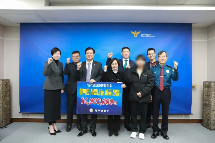 광주경찰청 안보자문협의회 임원들이 북한 이탈주민들에게 성금을 전달하고 기념 사진을  찍고 있다. (광주경찰청 제공)