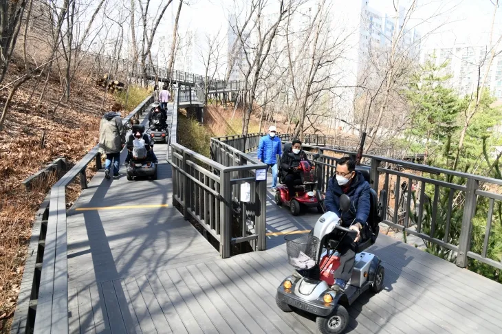 서울 노원구 주민들이 전동보장구를 이용해 순환산책로에서 산책하고 있다.   노원구 제공