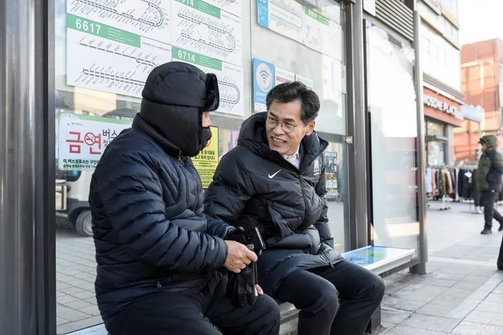 이기재(오른쪽) 서울 양천구청장이 버스정류장 온기의자에 앉아 시민과 대화를 하고 있다. 양천구 제공