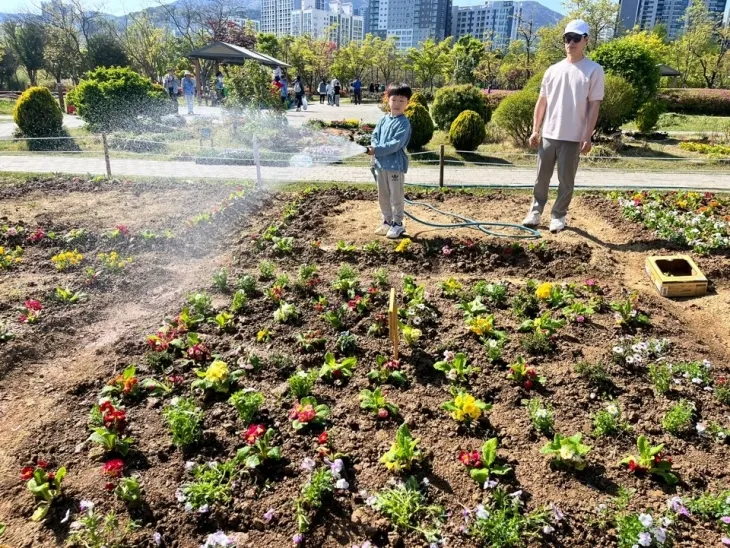 2024년 시민꽃밭 참가어린이가 물주기를 하고 있다 (부산시설공단 제공)