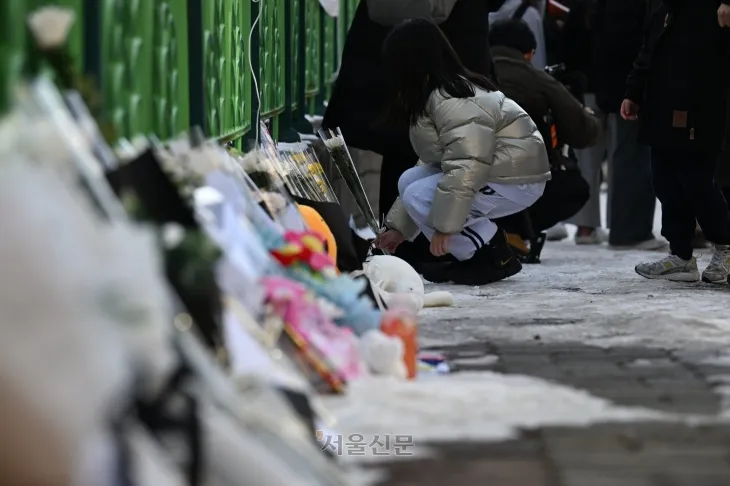 11일 오후 초등학생 피살사건이 발생한 대전 서구 관저동의 한 초등학교 정문 옆 담장에서 학생들이 국화꽃과 과자·음료 등을 놓으며 고 김하늘(8) 양을 추모하고 있다. 대전 홍윤기 기자