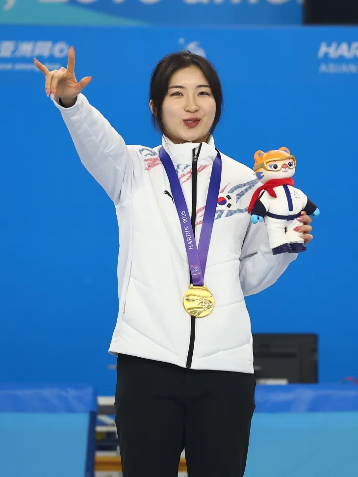 한국 쇼트트랙 국가대표 김길리가 8일 중국 하얼빈 헤이룽장 빙상훈련센터에서 열린 2025 하얼빈 동계아시안게임  여자 1500m에서 금메달을 딴 뒤 프로야구 KIA 타이거즈 김도영의 세레머니를 따라하고 있다. 하얼빈 연합뉴스