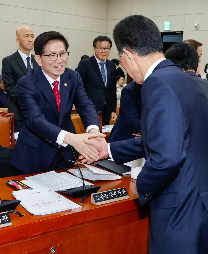 김문수(왼쪽) 고용노동부 장관이 20일 국회에서 열린 환경노동위원회 전체회의에 출석해 야당 간사인 김주영 더불어민주당 의원과 악수하고 있다.  뉴스1