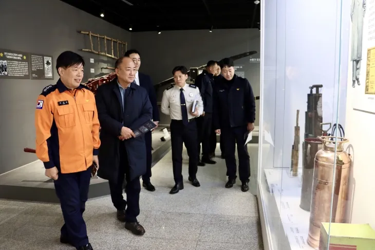 이영희 의원이 관계자들과 함께 소방 역사 관련 전시물을 둘러보며 설명을 듣고 있다.