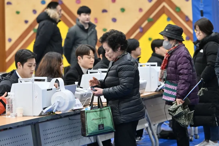 제1회 전국 동시 새마을금고 이사장 선거가 치러지는 5일 오전 광주 서구 양동초등학교에서 유권자들이 투표지를 받기 위해 신분증을 제시하고 있다. 뉴시스 제공